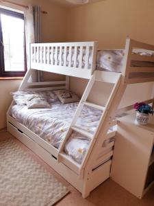 ein Schlafzimmer mit einem Etagenbett mit weißen Möbeln in der Unterkunft Bay Tree Cottage - cosy home near beach in Woolacombe + 16 Fotos
