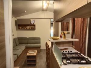 a kitchen and living room with a couch and a stove at Siblu Domaine de Kerlann mobile home LUMINOSA in Pont-Aven