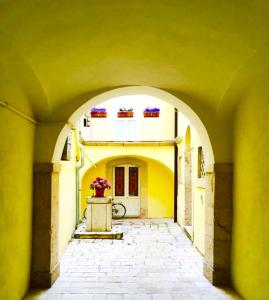 an archway leading to a building with a flower pot at La casa gialla in Campobasso