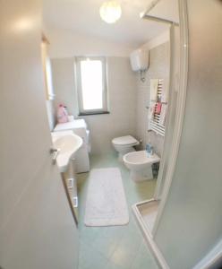 a bathroom with a toilet and a sink and a mirror at La vedetta di Castrocucco in Tortora +19 photos