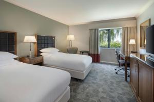 a hotel room with two beds and a desk at Delta Hotels by Marriott Northampton in Northampton +37 photos