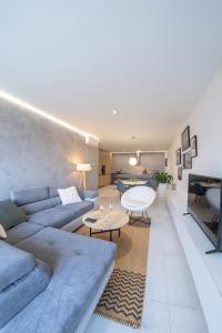 a living room with a blue couch and a table at Apartmán NAUTIS in Piešťany
