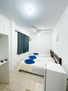 a bedroom with a bed in a white room at POUSADA MIRAMAR in Arraial do Cabo