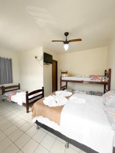 a bedroom with two beds and a ceiling fan at POUSADA MIRAMAR in Arraial do Cabo