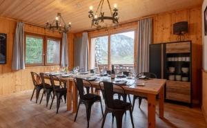 Chalet Les Arolles- Catered Chalet -Half Board في تينيِ: غرفة طعام مع طاولة خشبية طويلة وكراسي