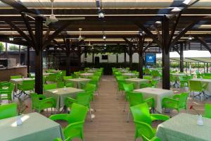 an empty restaurant with green tables and chairs at Adalya Resort & Spa Adults Only - Ultra All Inclusive in Side