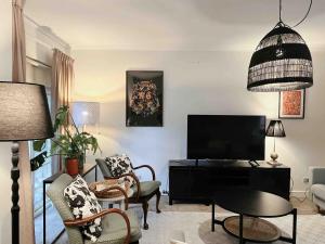 ein Wohnzimmer mit Fernseher und Tisch und Stühlen in der Unterkunft Peaceful cottage Burnside area in Burnside