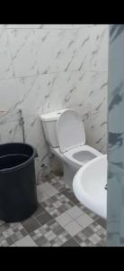 ein weißes Badezimmer mit Toilette und Waschbecken in der Unterkunft Villa Brastagi Gunung Mas B7 in Berastagi