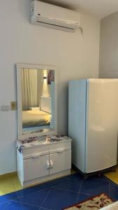 a room with a mirror over a dresser and a refrigerator at Chalet in Delta Sharm in Sharm El Sheikh +16 photos