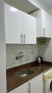 a kitchen counter with a sink and white cabinets at Chalet in Delta Sharm in Sharm El Sheikh