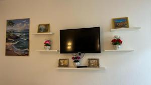 a flat screen tv on a wall with shelves at Chalet in Delta Sharm in Sharm El Sheikh