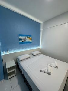 a bedroom with a white bed with a picture on the wall at Hotel Americas in Fortaleza +88 photos
