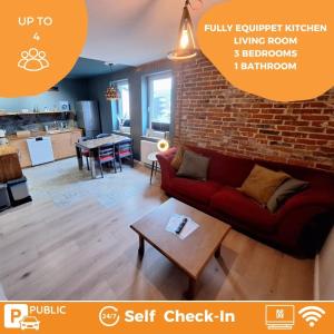 a living room with a red couch and a brick wall at Oerlinghausen, Gesamte stilvolle Wohnung, 3 Schlafzimmer, 4 Betten in Oerlinghausen