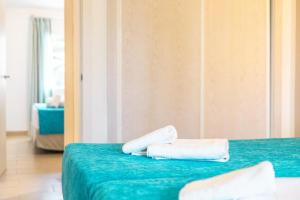 two towels on a green bed in a room at Seth Mestral & Llebeig in Santo Tomás +48 photos