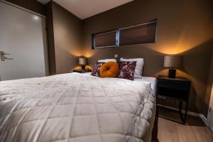 a bedroom with a large white bed with two lamps at Vakantiewoning Plantage 40 in Bruinisse