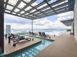 a swimming pool with chairs and a view of the water at Urban Loft MRT Convenience KLCC Nearby in EKO CHERAS in Kuala Lumpur