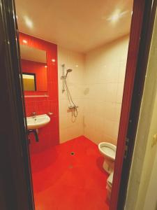 a red bathroom with a toilet and a sink at Къща за гости "Вила Релакс" in Apriltsi +47 photos