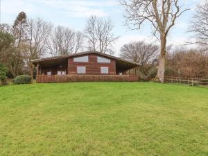 a house on a grassy hill with a tree at The Oak Lodge in Lyme Regis