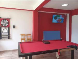 ein rotes Zimmer mit einer Tischtennisplatte in der Unterkunft Departamento Tio Iguazú in Puerto Iguazú