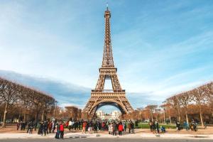 eine Gruppe von Personen, die vor dem Eiffelturm stehen in der Unterkunft cozy Nest,Paris,Opera,Disney,La Défense, in Bondy