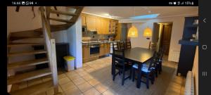 una cucina con tavolo e sedie e una scala di Chalet 4d en Panticosa en urbanización con piscina y padel a Panticosa