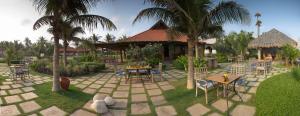 a patio with tables and chairs and palm trees at The Park Visakhapatnam in Visakhapatnam