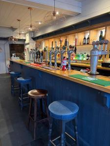 a bar with blue bar stools in a room at The Mariners in Falmouth +27 photos