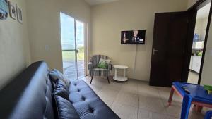 a living room with a leather couch and a table at Casa do Farol - Frente para a praia in Itapoa
