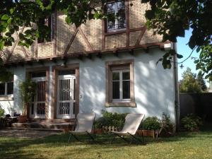 two chairs sitting in front of a house at Le Petit Parc in Colmar