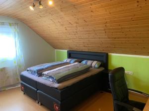 two beds in a room with a wooden ceiling at Ferienwohnung Ortenau in Neuried