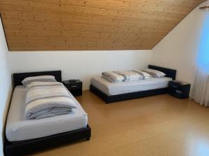 two beds in a room with a wooden ceiling at Ferienwohnung Ortenau in Neuried