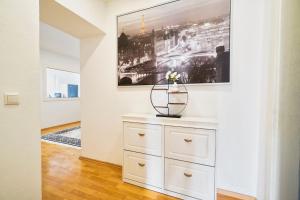 a white dresser in a room with a painting on the wall at Premium Apartment in Tiddische
