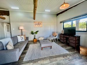 a living room with a couch and a tv at Hephzibah Inn Farm Cottage in Hermon
