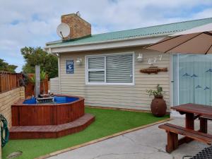 a backyard with a hot tub and a picnic table at Bokkompie in Uilkraalmond