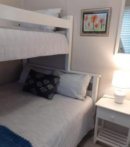 a bedroom with a bunk bed and a nightstand with a nightstand at Bokkompie in Uilkraalmond +23 photos