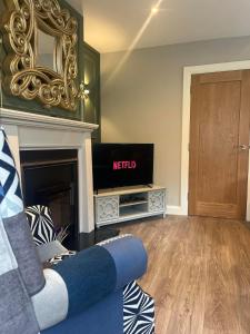 a living room with a tv and a fireplace at Laurel cottage in Omagh +29 photos
