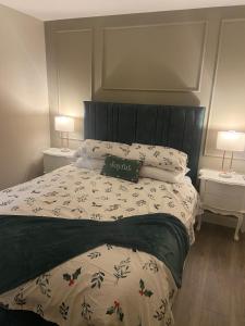 a bedroom with a bed with a black headboard and two lamps at Laurel cottage in Omagh