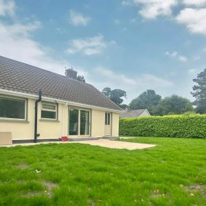 a house with a green lawn in front of it at Laurel cottage in Omagh