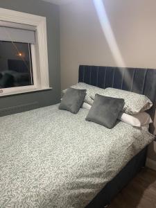 a bedroom with a bed with two pillows and a window at Laurel cottage in Omagh