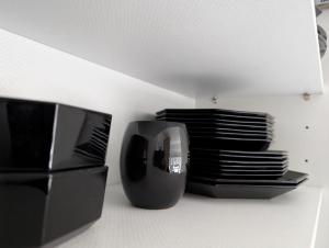 a shelf with a microwave and a stack of plates at Appartment-19-Sylter-Robbe in Wenningstedt