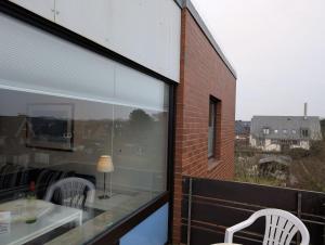 a balcony with two chairs and a table and a window at Appartment-19-Sylter-Robbe in Wenningstedt +9 photos