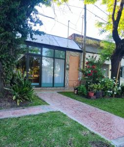 a building with glass doors and plants in a yard at Dorita in Villa Elisa