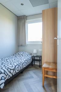 een slaapkamer met een bed en een raam bij Vakantiewoning aan het water in Yerseke in Yerseke