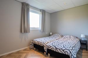 een slaapkamer met een bed en een raam bij Vakantiewoning aan het water in Yerseke in Yerseke