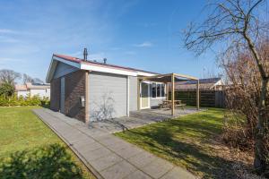 een klein huis met een picknicktafel in een tuin bij Vakantiewoning aan het water in Yerseke in Yerseke