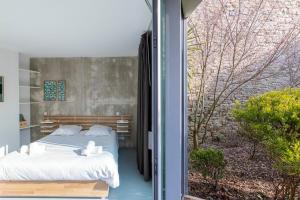 ein Schlafzimmer mit einem Bett und einem großen Fenster in der Unterkunft Habiter la ville, un art contemporain in Vannes