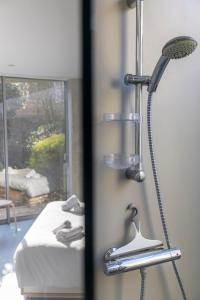 eine Dusche in einem Zimmer neben einem Bett in der Unterkunft Habiter la ville, un art contemporain in Vannes