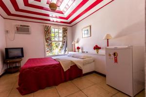 een slaapkamer met een bed met een rood en wit gestreept plafond bij Pousada Búzios Summer Park in Búzios