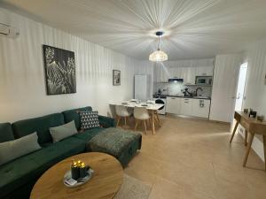 Spacieux 2 pieces au Port de Nice في نيس: غرفة معيشة مع أريكة خضراء وطاولة