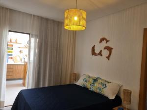 ベラ・クルス・デ・イタパリカにあるBeachhouse Costa de Aratubaのベッドルーム(青いベッド1台、シャンデリア付) +40枚の写真